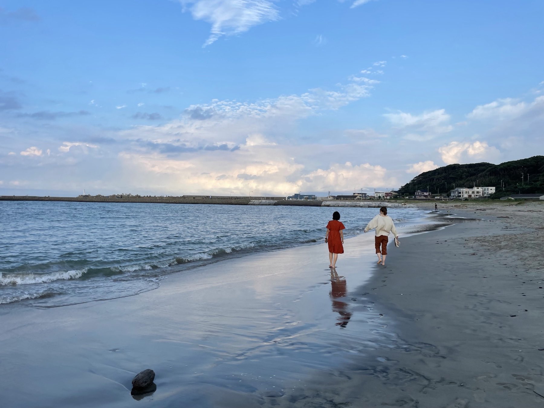 夕暮れの阿字ヶ浦海岸を歩く2人